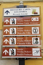 Italy, Lombardy, Cremona, violin maker's signs around city.