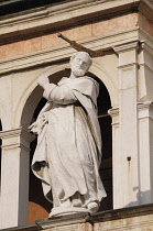 Italy, Lombardy, Cremona, Statue of St Peter the martyr on facade of Duomo.