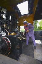 Transport, Rail, Steam Train, Watercress Line engine fireman loading the boiler with coal.