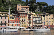 Italy, Liguria, Portofino, waterside houses with sailing boats in the bay.