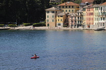 Italy, Liguria, Portofino Peninsula, colourful houses & bay with canoeist near Portofino.