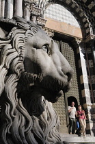 Italy, Liguria, Genoa, stone lion with people leaving the Duomo.