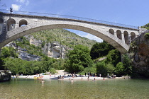 France, Lozere, St Chely du Tarn, Gorges du Tarn, Bridge over the Tarn connecting St Chely du Tarn with main road, Visitors swimming, sunbathing and canoeing beneath the bridge.