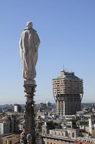 Italy, Lombardy, Milan, Duomo spires with statue and city views.