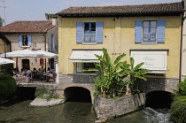 Italy, Lombardy, Vallegio Sul Mincio, river & restaurants in the Borgo Old Town.
