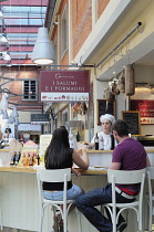 Italy, Piedmont, Turin, couple dining at bar at Eataly, Slow Food store, Lingotto.
