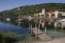 Italy, Lombardy, Lake Orta, Pella, Waterfront buildings and moored boats with wooden jetty.