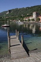 Italy, Lombardy, Lake Orta, Pella, Waterfront buildings and moored boats with wooden jetty.