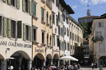 Italy, Friuli Venezia Giulia, Udine, cafes lined along Piazza Mateotti with Castle above.