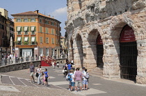 Italy, Veneto, Verona, Arena exterior on Piazza Bra with people walking past.