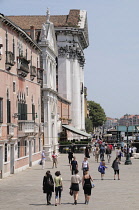Italy, Veneto, Venice, Zattere, people walking along Fondamente Zattere beside Gesuati Church.