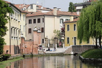 Italy, Veneto, Treviso, canal & building with fishing wall painting.