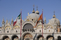 Italy, Veneto, Venice, domes of the Basilica of San Marco with flags.