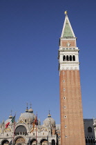 Italy, Veneto, Venice, domes of the Basilica of San Marco with flags and Campanile bell tower.