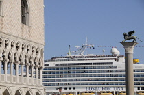 Italy, Veneto, Venice, Palazzo Ducale with cruise ship passing Piazza San Marco.