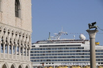 Italy, Veneto, Venice, Palazzo Ducale with cruise ship passing Piazza San Marco.