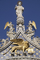 Italy, Veneto, Venice, Gold Lion of St Mark & statue of St Mark, Basilica San Marco facade.