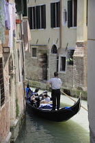 Italy, Veneto, Venice, gondola passing through narrow canal in Arsenale.