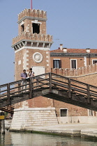 Italy, Veneto, Venice, Arsenale, bridge with couple & the walls of the Arsenale.