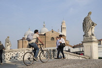 Italy, Veneto, Padua, cyclist crossing bridge on Isola Memmia e Zairo Teatro Romano, Prato della Valle.