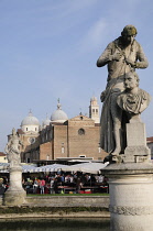 Italy, Veneto, Padua, statue on Isola Memmia e Zairo Teatro Romano, Prato della Valle with Basilica San Guistina.