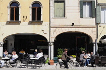 Italy, Friuli Venezia Giulia, Udine, Piazza Mateotti with cafes & cyclist.
