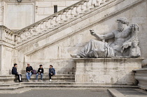 Italy, Lazio, Rome, Capitoline Hill, Piazza del Campidoglio, sitting around the statuary, Palazzo Senatorio.
