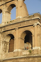 Italy, Lazio, Rome, Colosseum, Upper level arches of the Colosseum with people looking from viewpoint.