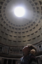 Italy, Lazio, Rome, Centro Storico, Pantheon, child looking up at oculus with light shining through.