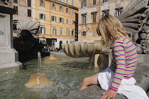 Italy, Lazio, Rome, Trastevere, Piazza di Santa Maria de Trastevere, child cooling off in fountain.
