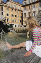 Italy, Lazio, Rome, Trastevere, Piazza de Santa Maria de Trastevere, child cooling off in the fountain.