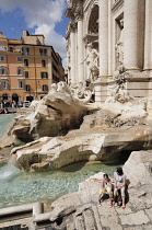 Italy, Lazio, Rome, Centro Storico, Trevi Fountain, people sitting beside fountain.