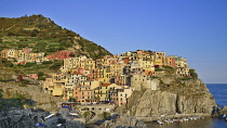 Italy, Liguria, Cinque Terre, Manarola, General vista of the town bathed in evening sunshine as seen from Punta Bonfiglio opposite.