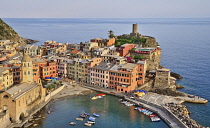 Italy, Liguria, Cinque Terre, Vernazza, View of the Church of Santa Margherita di Antiochia and Castello Doria with its Belforte Tower above the harbour from high up on the Sentiero Azzurro or Blue Tr...