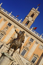 Italy, Lazio, Rome, Piazza del Campidoglio designed by Michelangelo, Angular view of the statue of the Roman Emperor Marcus Aurelius on horseback with the clock tower of Palazzo Senatorio in the backg...