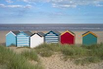 England, Suffolk, Southwold, Group of brightly coloured beach huts near Gun Hill.