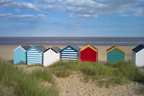 England, Suffolk, Southwold, Group of brightly coloured beach huts near Gun Hill.