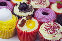 Studio shot of various colouful and decorated cup cakes.