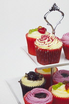 Studio shot of colourfully decorated cupcakes on cake stand.