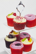 Studio shot of colourfully decorated cupcakes on cake stand.