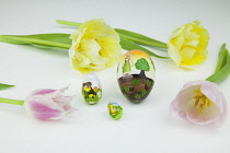 Studio shot of tulip flowers with painted eggs for Easter.
