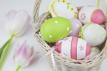 Studio shot of decorated Easter eggs in a wicker basket.