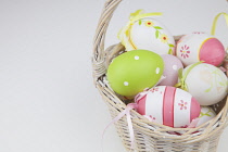 Studio shot of decorated Easter eggs in a wicker basket.