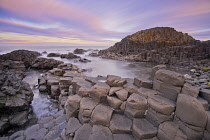Ireland, County Antrim, Giants Causeway, Dramatic colourful cloud pattern over the rocks at sunrise.