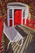 Ireland, County Mayo, Westport, Red Georgian style doorway with seat in driveway.