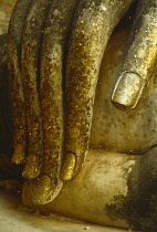 Thailand, North, Sukhothai, Wat Si Chum. Detail of hand of massive seated Buddha figure scattered with pieces of gold leaf by worshippers.