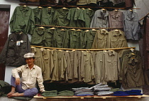 Vietnam, North, Hanoi, Man selling military surplus clothing in street.