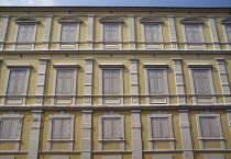 Thailand, Bangkok, Building facade showing three stories of closed window shutters.