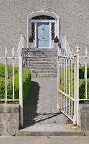 Ireland, County Offaly, Birr which is a town renowned for its Georgian architecture, John's Mall, elegant light blue Georgian doorway with steps leading up to it and an ornamental white railing gate.