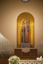 Italy, Tuscany, Lucca, Barga, Interior of church with statue, altar and organ pipes visible.